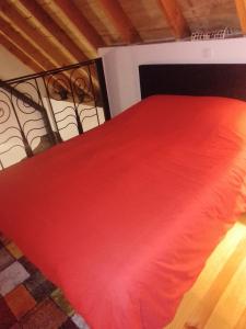 a bedroom with a red bed with a red blanket at La Loge de Fleur in Anglars-Saint-Félix