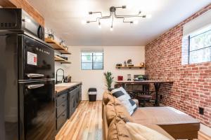 a kitchen with a couch and a brick wall at Awaken Your Senses King Bed Bsu Parking in Boise