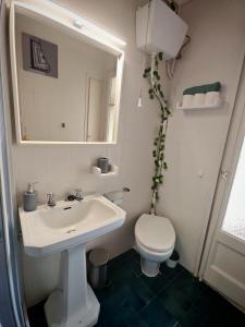 a bathroom with a sink and a toilet and a mirror at Villa Pescadors 3HB 5 MIN al mar & auto check in in Sant Carles de la Ràpita +17 photos