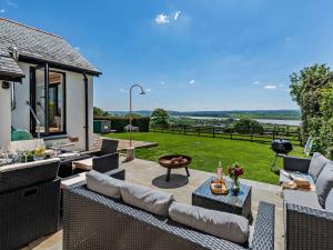 a patio with wicker furniture and a view of a yard at 3 Bed in Braunton 53109 in Braunton