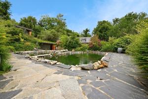 a pond in the middle of a garden at Cabane Petit Bouddha in Arrien-en-Bethmale