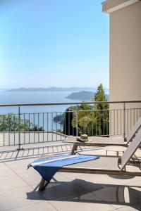 a table on a balcony with a view of the ocean at Hôtel La Villa Douce in Rayol-Canadel-sur-Mer