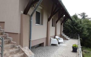 una casa con patio y 2 sillas blancas en Apartments in Badacsony - Balaton 50626, en Badacsony