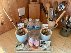 a table with two cups and bottles of water at Willowdene shepherds hut in Oswestry