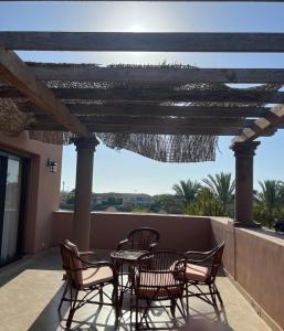 eine Terrasse mit Tisch und Stühlen auf einem Balkon in der Unterkunft Town House in Veneto Residence Marassi in El-Alamein