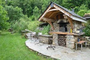 a stone oven with a table and chairs outside at Roulotte Appoline in Arrien-en-Bethmale