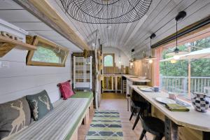 a tiny house with a long bench and a table at Roulotte Appoline in Arrien-en-Bethmale
