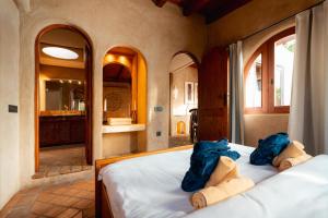 ein Schlafzimmer mit einem Bett mit zwei blauen Taschen darauf in der Unterkunft El Refugio Apartments & Villa in La Matanza de Acentejo