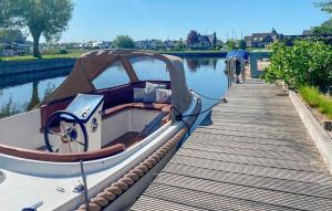 ein Boot, das neben einem Holzsteg angedockt ist in der Unterkunft Three Bedroom Awesome Home In Lemmer in Lemmer + 10 Fotos