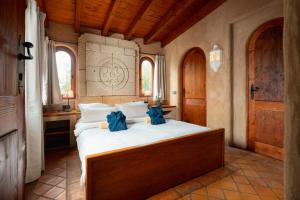 ein Schlafzimmer mit einem großen Bett mit blauen Bogen darauf in der Unterkunft El Refugio Apartments & Villa in La Matanza de Acentejo + 37 Fotos
