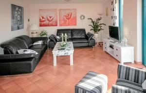 ein Wohnzimmer mit einer schwarzen Couch und einem Tisch in der Unterkunft Three Bedroom Awesome Home In Lemmer in Lemmer