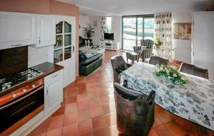 eine Küche mit einem Tisch und Stühlen sowie eine Küche mit einem Herd in der Unterkunft Three Bedroom Awesome Home In Lemmer in Lemmer