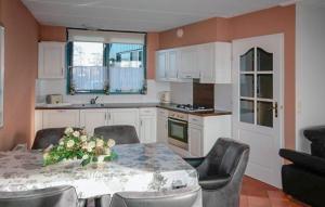 eine Küche mit einem Tisch und Stühlen sowie eine Küche mit einem Tisch und einem Tisch in der Unterkunft Three Bedroom Awesome Home In Lemmer in Lemmer