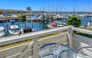 鲁德克丙Cozy Apartment In Rudkøbing With Wifi - G11307的阳台上的桌子上有一个码头,上面有船