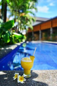 a drink sitting on a table next to a swimming pool at Mayfair Garden Resort in Panglao