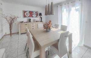 a white kitchen with a table and white chairs at Nice Home In Cessenon Sur Orb - Flh677 in Cessenon