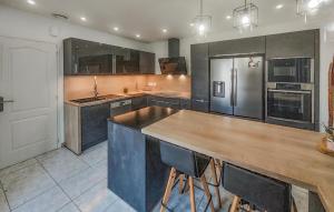 a large kitchen with a wooden counter top and appliances at Nice Home In Cessenon Sur Orb - Flh677 in Cessenon
