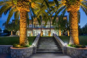 a building with palm trees in front of it at Iris Hotel in Siviri