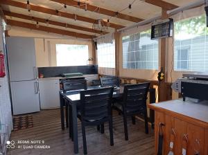 a kitchen with a table and chairs and a refrigerator at Mobilhome 4-6 personnes confort-piscine-mer meschers sur gironde in Meschers-sur-Gironde