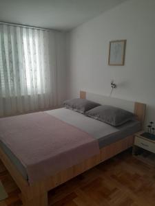 a bedroom with a large bed with a window at Apartments Samaržija- new 63 not 47 in Bibinje