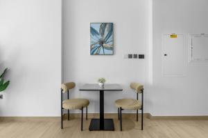 a table and chairs in a white room with a picture at Modern Studio In Jlt Cluster L Top Facilities in Dubai