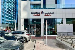 a car dealership with cars parked in front of a building at Modern Studio In Jlt Cluster L Top Facilities in Dubai