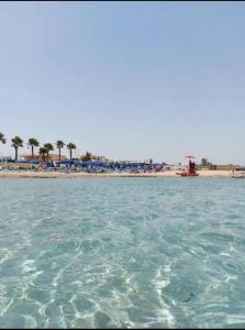 a body of water with a beach in the background at Profumo di Mare Fronte Spiaggia in Noto Marina