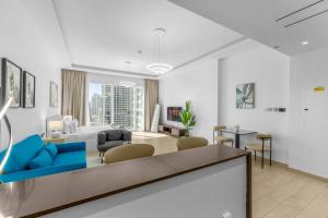 a white living room with a blue couch and chairs at Modern Studio In Jlt Cluster L Top Facilities in Dubai