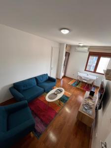 a living room with a blue couch and a table at DOWNTOWN apartment Old Town in Podgorica