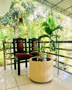 a balcony with a chair and a potted plant at Executive Room in Kelakam +4 photos