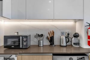 a kitchen counter with a microwave and some utensils at Modern Studio In Jlt Cluster L Top Facilities in Dubai