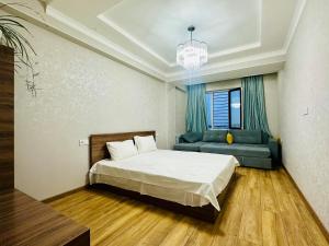 a bedroom with a bed and a couch in it at WOOD apartments in Osh