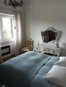 a bedroom with a large bed and a mirror at Casa de alojamento local (T2) Queluz de Baixo in Oeiras