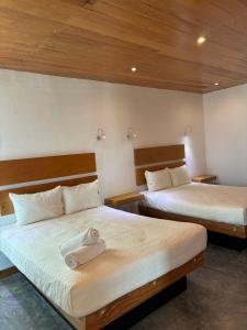 a bedroom with two beds with towels on them at Live the Beach Life Luxury, Location and Total Comfort in Playa del Carmen