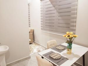 a dining room table with a vase of flowers on it at The Base at Goba Hills in Dar es Salaam +2 photos