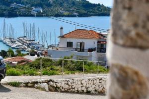 a house on a hill next to a harbor with boats at Selanna Luxury Apartments in Skiathos Town