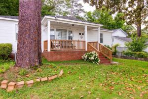 una casa con un porche y un árbol en Serene Walkable Fam Stay w/Toys!, en Phenix City