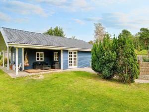 a blue house with a patio and a yard at 9 person holiday home in Jægerspris-By Traum in Jægerspris