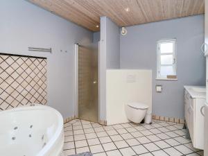a bathroom with a tub and a toilet and a sink at 9 person holiday home in Jægerspris-By Traum in Jægerspris