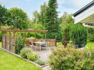 a patio with a table and chairs in a garden at 9 person holiday home in Jægerspris-By Traum in Jægerspris