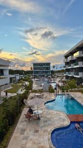 a resort with a swimming pool and a building at Flat Inteiro no Makia Beach Experience in Porto De Galinhas