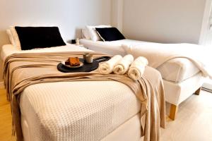 two beds with towels and a tray of food on them at SariStays Valencia City Center L in Valencia