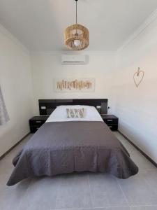 a bedroom with a large bed and a chandelier at Villa Kiki in Morche