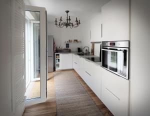 a kitchen with white cabinets and a chandelier at Ferienwohnung am Park in Neustadt an der Weinstraße +8 photos