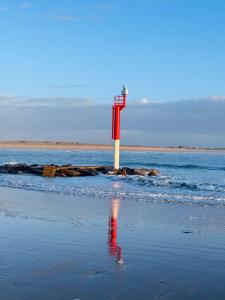 a red and white lighthouse in the middle of the ocean at Au petit Cachou in Port-Bail-sur-Mer +5 photos