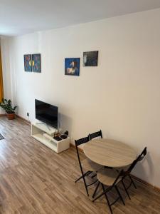 a living room with a table and chairs and a television at Vadim's guesthouse in Sibiu +4 photos