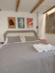 a bed with two rolled towels on top of it at Casa Vieja de Rauco, casa patrimonial en el campo in Curicó