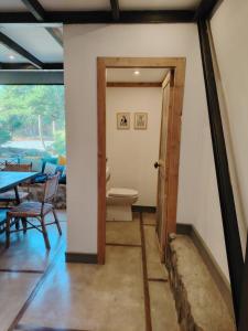 a door to a room with a table and a toilet at Casa Vieja de Rauco, casa patrimonial en el campo in Curicó +26 photos