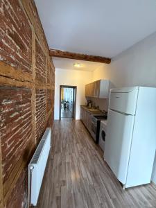 a kitchen with a refrigerator and a brick wall at Vadim's guesthouse in Sibiu