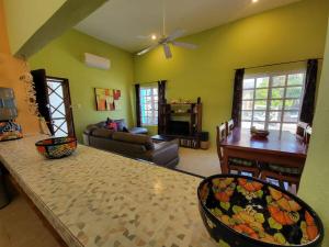 a living room with green walls and a table and chairs at Condo on the Caribbean in Isla Mujeres